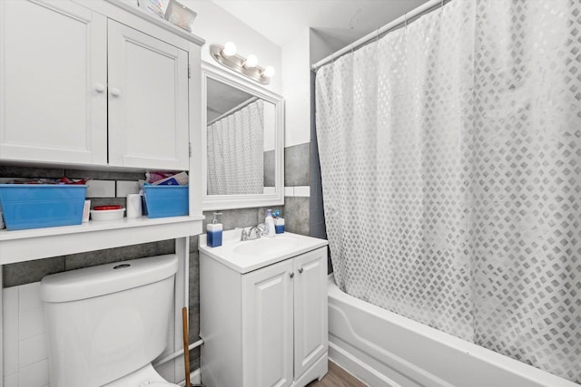 full bathroom featuring tile walls, toilet, vanity, and shower / bath combo with shower curtain