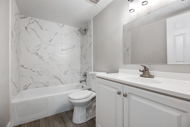 full bathroom with tiled shower / bath, vanity, and toilet