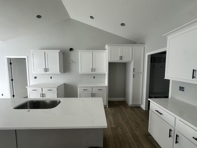 kitchen featuring white cabinetry, light stone counters, dark hardwood / wood-style flooring, and lofted ceiling