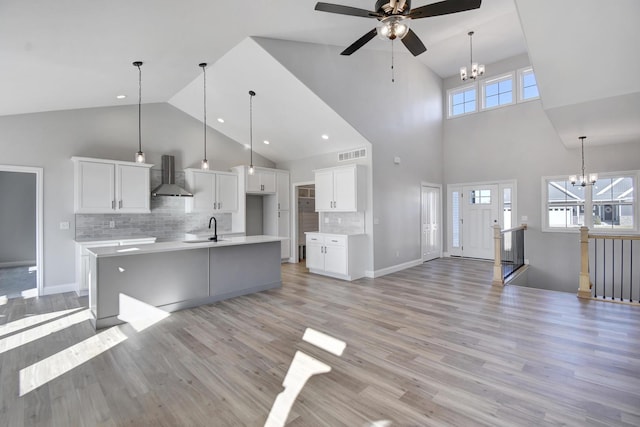 1713 Littlefield Ln, Mahomet, IL 61853 - kitchen with wall chimney range hood, a sink, high vaulted ceiling, a chandelier, and ceiling fan