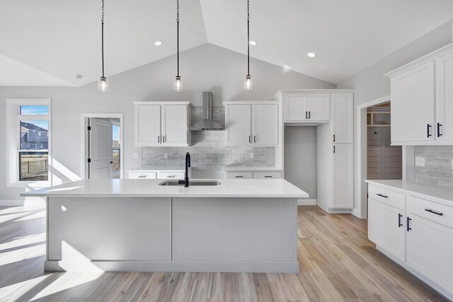 1713 Littlefield Ln, Mahomet, IL 61853 - kitchen with wall chimney exhaust hood, vaulted ceiling, a sink, white cabinetry, and backsplash