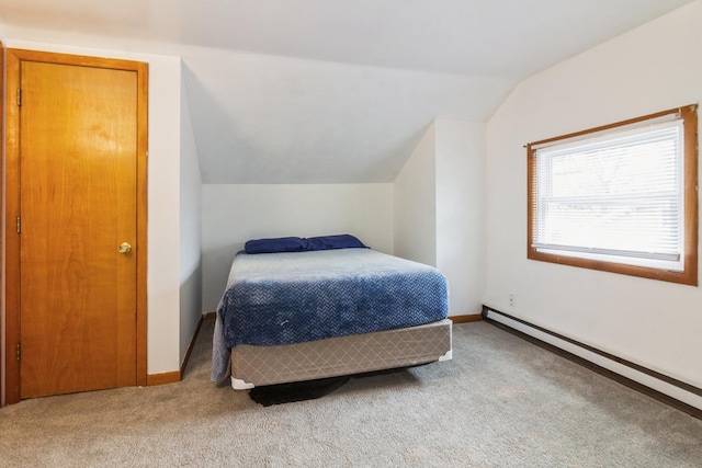 carpeted bedroom with lofted ceiling, baseboard heating, and baseboards