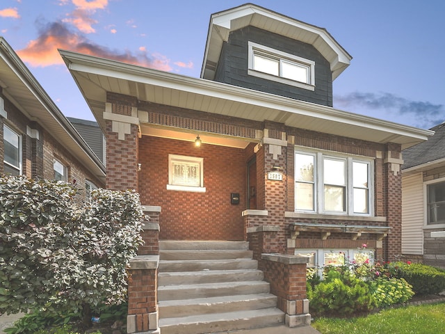 exterior entry at dusk featuring covered porch