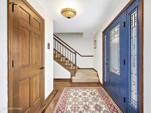 entrance foyer with stairway, baseboards, and wood finished floors