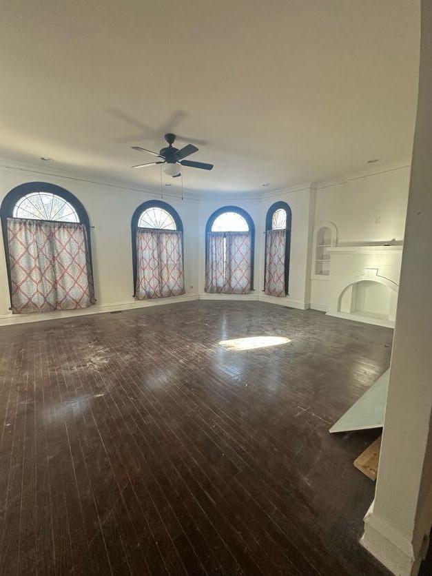 interior space featuring a healthy amount of sunlight, dark hardwood / wood-style floors, and crown molding