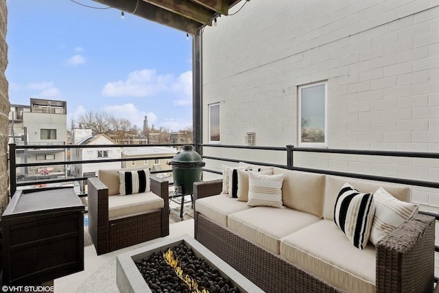 balcony featuring an outdoor living space with a fire pit