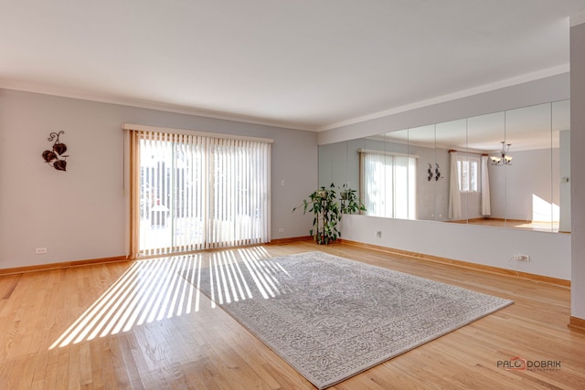 unfurnished living room featuring crown molding, wood-type flooring, and a notable chandelier