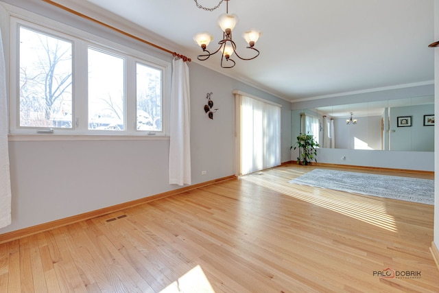 unfurnished dining area with crown molding, light hardwood / wood-style flooring, and a notable chandelier