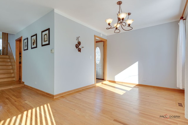 empty room with an inviting chandelier and light wood-type flooring