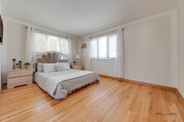 bedroom featuring ornamental molding and light hardwood / wood-style floors