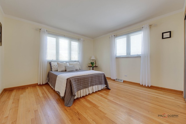 bedroom with ornamental molding and hardwood / wood-style floors