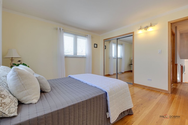 bedroom featuring ornamental molding, a closet, and light wood-type flooring