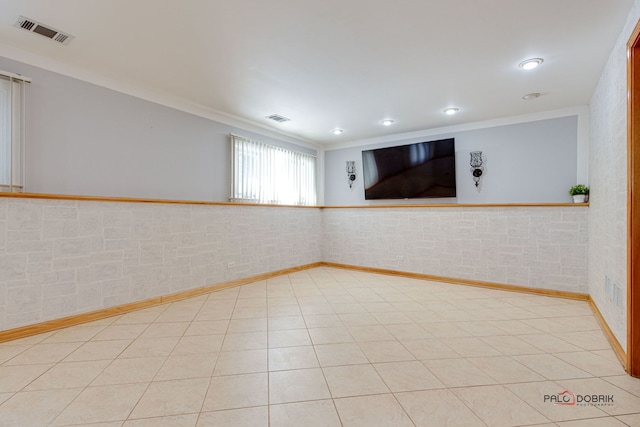 empty room with ornamental molding and light tile patterned floors