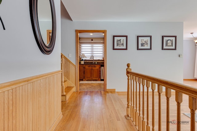 corridor featuring sink and light hardwood / wood-style floors