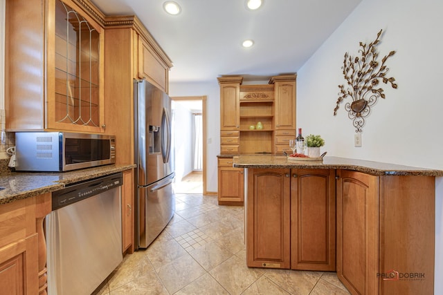 kitchen with stainless steel appliances and dark stone counters