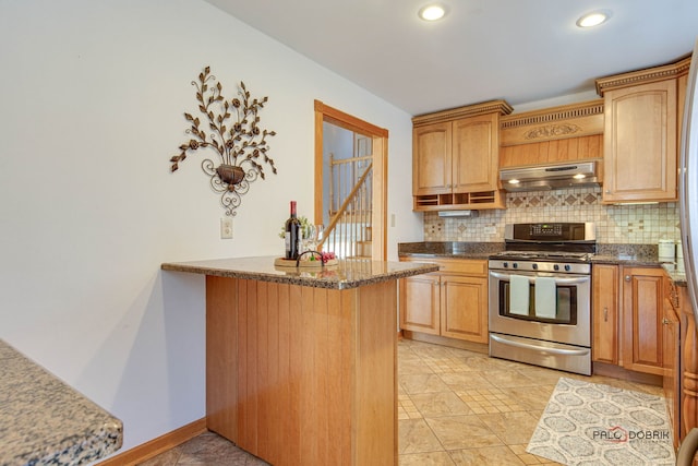 kitchen featuring tasteful backsplash, stainless steel gas range, dark stone counters, and kitchen peninsula