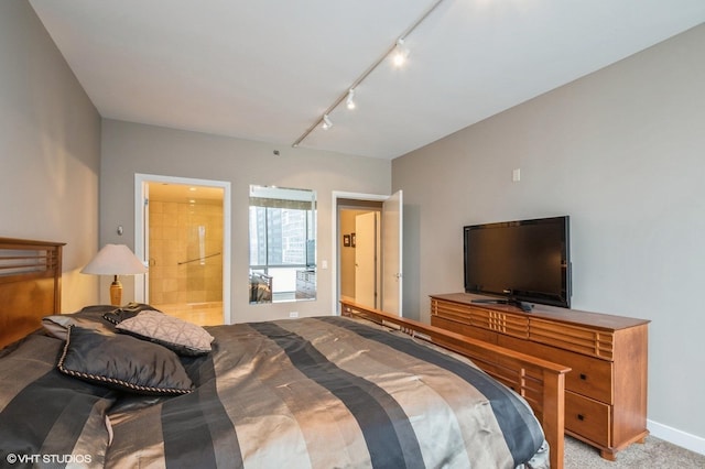 carpeted bedroom featuring connected bathroom and rail lighting