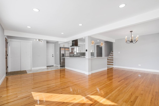 unfurnished living room featuring light hardwood / wood-style floors and a notable chandelier