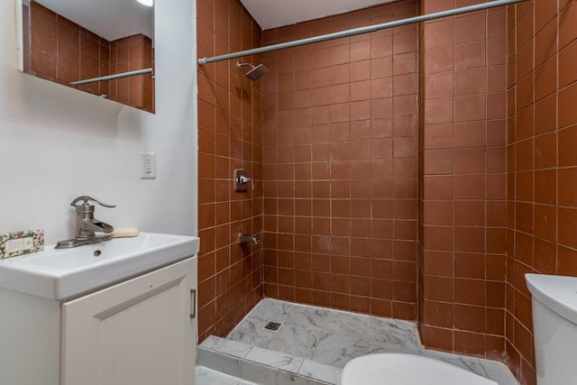 bathroom featuring vanity, toilet, and a tile shower