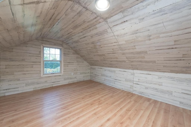 bonus room with wood ceiling, vaulted ceiling, light hardwood / wood-style floors, and wooden walls