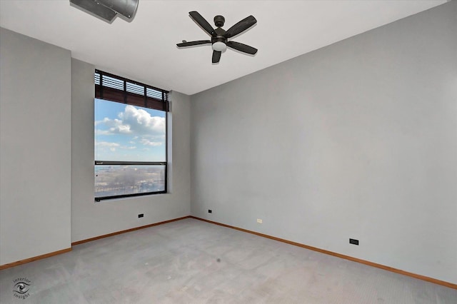 empty room with baseboards, a ceiling fan, and light colored carpet