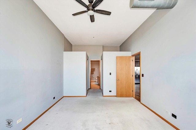 unfurnished bedroom featuring baseboards, ensuite bathroom, and light colored carpet