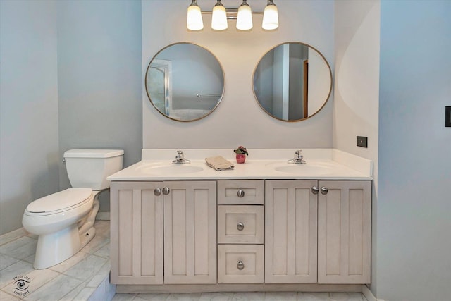 full bathroom featuring marble finish floor, a sink, toilet, and double vanity