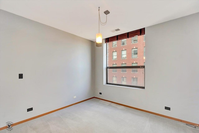 empty room with light colored carpet, visible vents, and baseboards