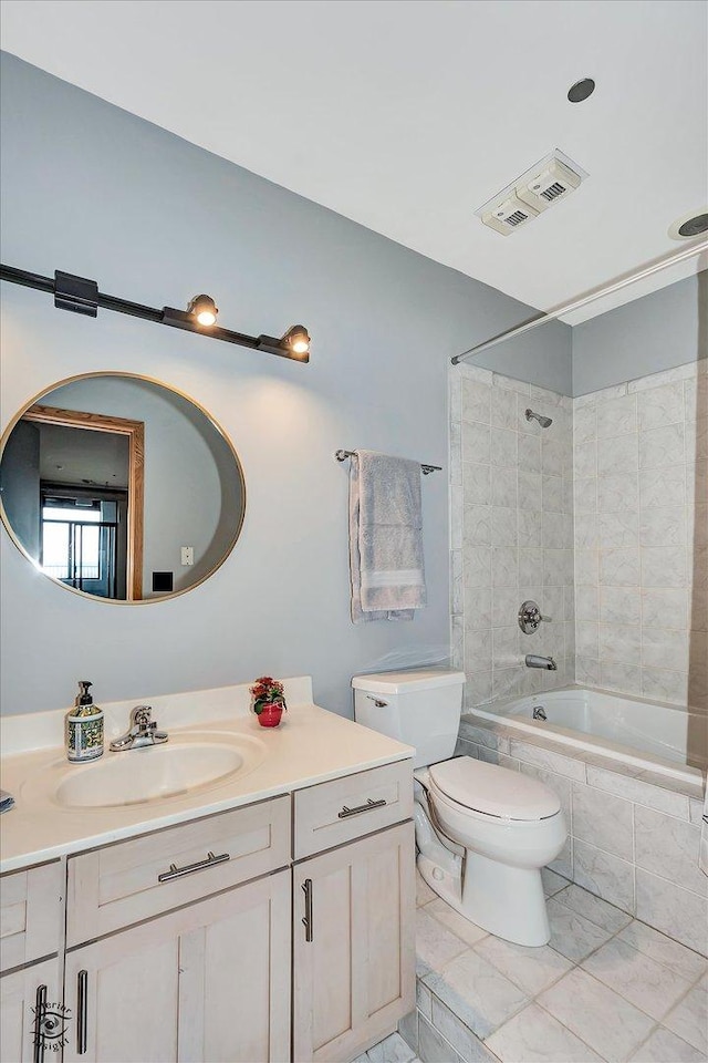 full bathroom featuring toilet, tiled shower / bath, visible vents, and vanity