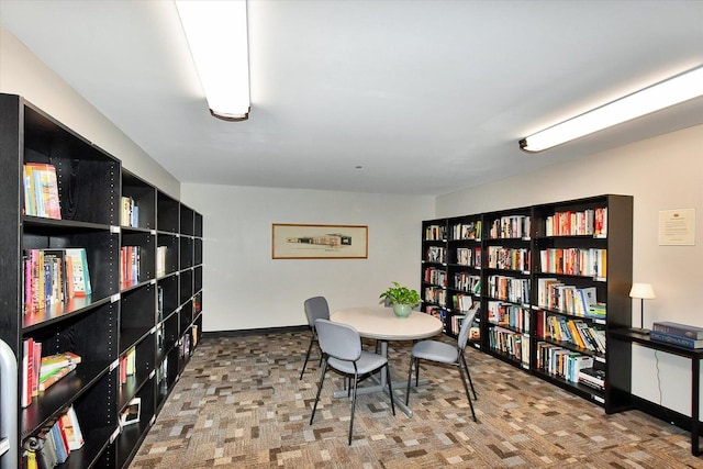 office featuring wall of books and baseboards