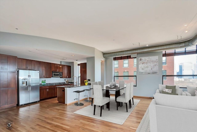 dining room with light wood-type flooring and baseboards