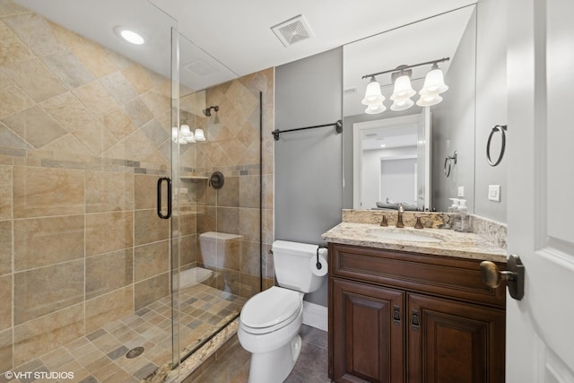 bathroom featuring vanity, a shower with door, and toilet