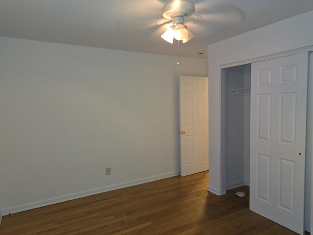 unfurnished bedroom with ceiling fan, dark hardwood / wood-style floors, and a closet