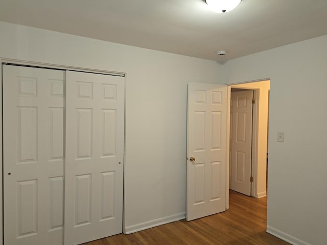 unfurnished bedroom with a closet and hardwood / wood-style floors