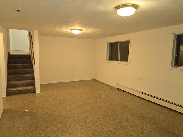 basement featuring a textured ceiling and baseboard heating