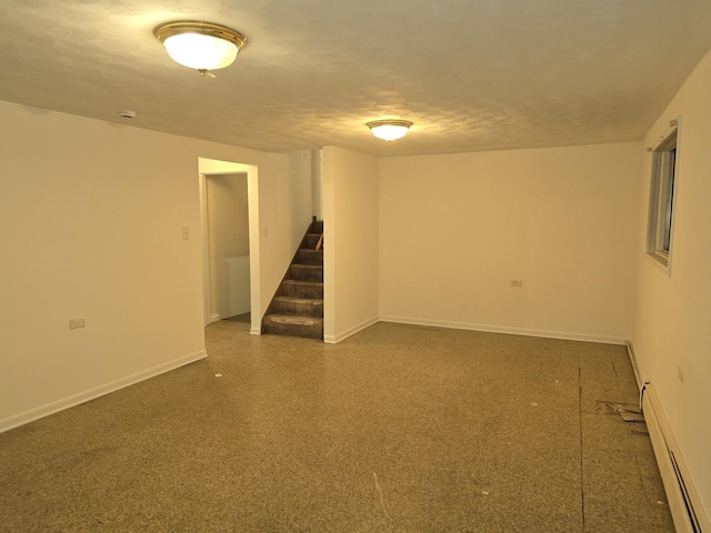 basement with a baseboard heating unit and a textured ceiling