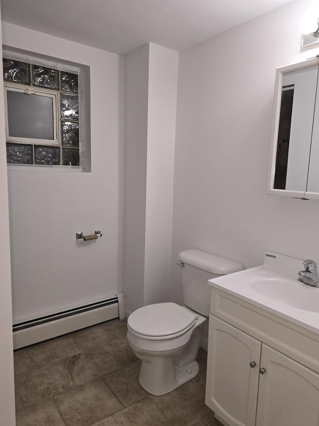 bathroom with toilet, vanity, and baseboard heating