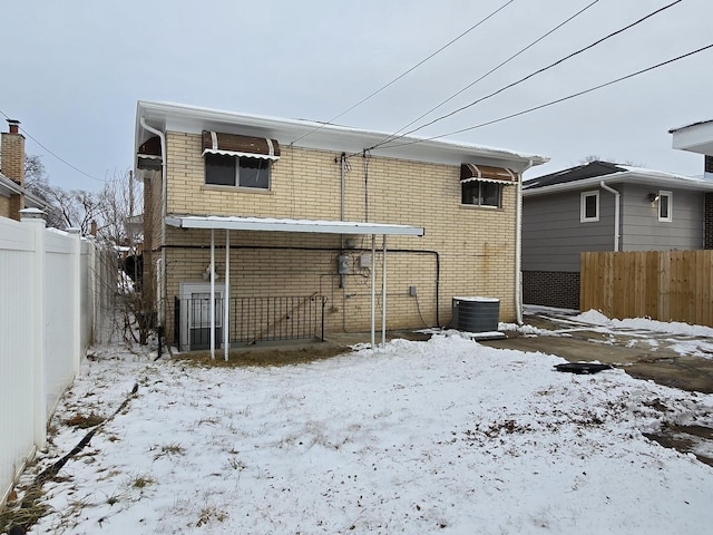 snow covered house with central AC unit