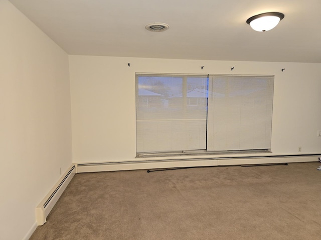 empty room with carpet flooring and a baseboard heating unit