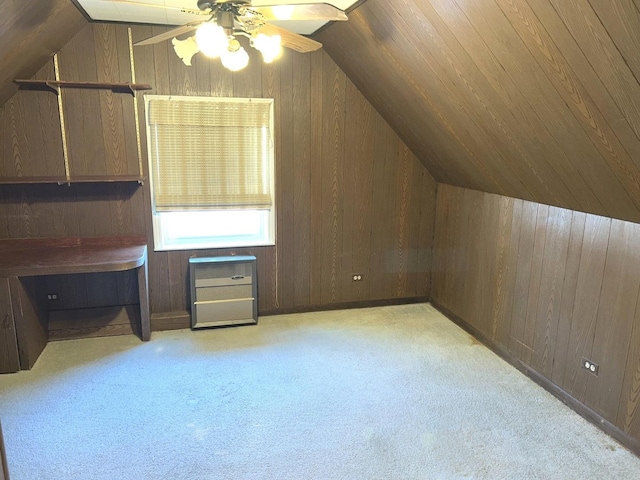 bonus room with wood walls, vaulted ceiling, and carpet flooring