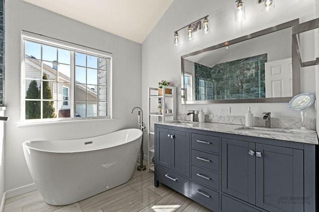 bathroom with lofted ceiling, a sink, and a wealth of natural light