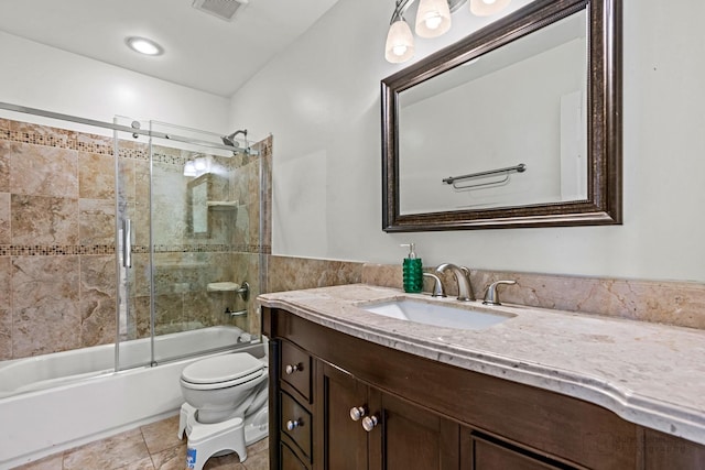 bathroom featuring shower / bath combination with glass door, visible vents, toilet, vanity, and tile patterned floors