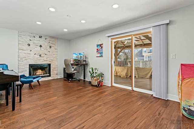 interior space featuring baseboards, a fireplace, wood finished floors, and recessed lighting