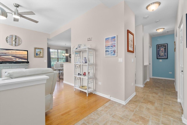 hallway with light hardwood / wood-style flooring and a notable chandelier