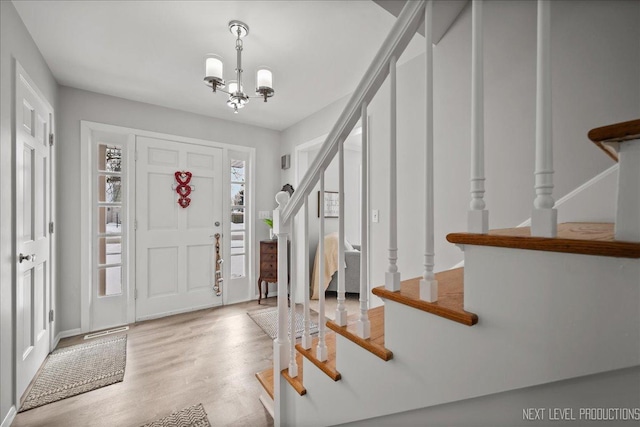 foyer featuring light wood-type flooring and an inviting chandelier