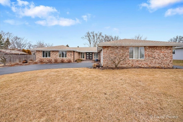 ranch-style home with fence, brick siding, driveway, and a front yard