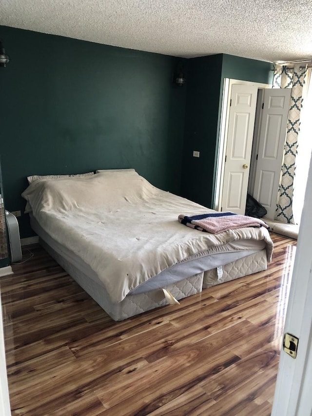 bedroom with dark wood-type flooring and a textured ceiling