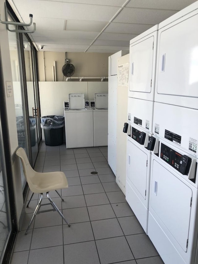 washroom with stacked washer and dryer, washer and clothes dryer, and dark tile patterned floors