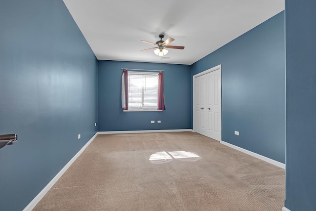 carpeted spare room featuring ceiling fan