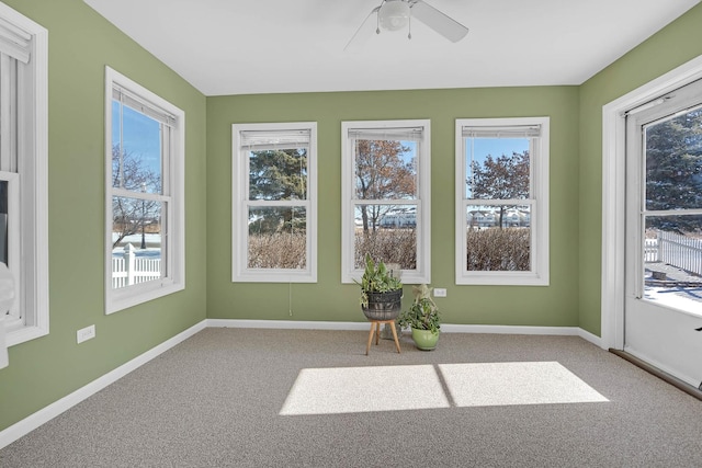 unfurnished sunroom featuring ceiling fan